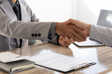An employer shakes hands of a male job applicant congratulating the position. The HR manager is happy to hire job applicants to shake hands. A good interview idea that succeeds in a friendly manner le