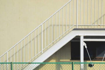 Yellow walls, metal stairs and windows, and a green fence / 黄色い壁に金属の階段と窓と緑の柵
