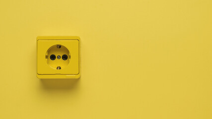 Yellow electrical outlet on a yellow background. Space for text.