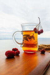 Black tea and rose hips on the background of a cloudy sky