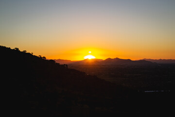 atardecer desde la montaña y la ciudad de fondo