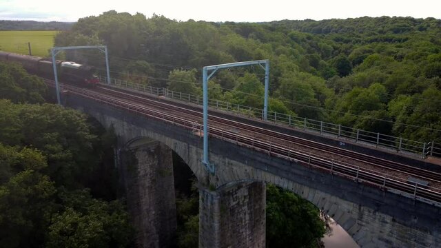 Flying Scotsman Steam Train passes over Pegswood Viaduct, Morpeth, Northumberland. Dolly shot.