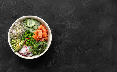 Keto diet poke bowl with salmon, avocado, and edamame beans. over dark background. Banner, top...