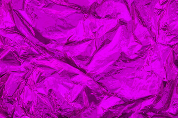 Purple crumpled, creased iridescent metal foil texture. Abstract shiny colored background. Monochrome, minimal surface.