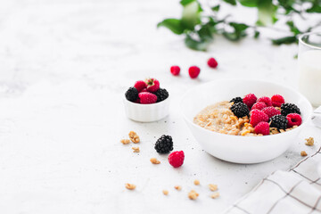 Breakfast bowl with granola, muesli, raspberry, blackberry on gray table
