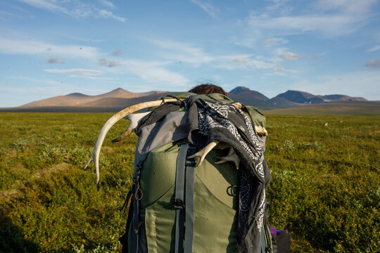 Man trekking on the background of the mountain with a heavy travel backpack. Travel lifestyle adventure concept. Summer travel outdoors alone in the wild.