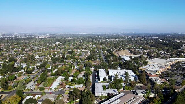 Sunnyvale City Aerial view with trees, main road, houses, and mountains in background in the afternoon drone move forward