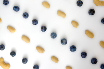 Full frame closeup forest fruit fresh berries colorful assorted large mix in studio on white background. Isolated yummy food pattern of Peanuts, cashews, domesticated, wild blueberries