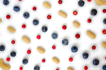 Full frame closeup forest fruit fresh berries colorful assorted large mix in studio on white background. Isolated yummy food pattern of Peanuts, cashews, domesticated, wild blueberries, lingonberries 