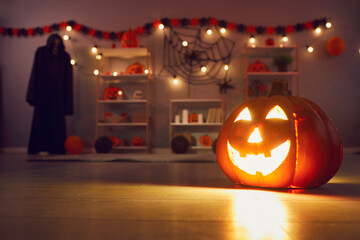 Festive background with beautiful smiley carved jack-o-lantern pumpkin with lit candle inside...