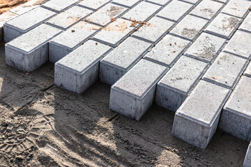Pavement repair and laying of paving slabs on the walkway, stacked tile cubes on the background. Laying paving slabs in the pedestrian zone of the city, sand filling. Road tiles and curbs.