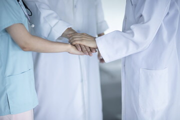 Close-Up Of Doctors Stacking Hands