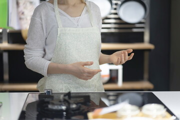 Woman in apron posing in kitchen