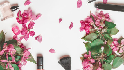 Obraz na płótnie Canvas Flat lay composition with cosmetic products for makeup and pink apple flowers on a white background