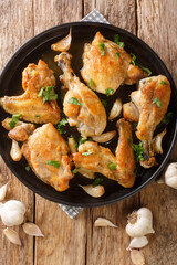 Spanish Garlic Chicken Pollo Al Ajillo close-up on a plate on the table. Vertical top view from above