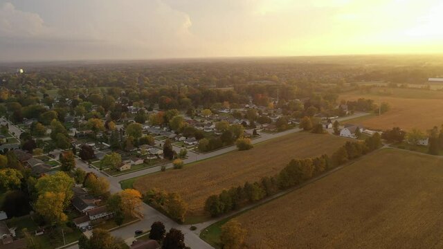 Aerial Midwest suburban neighborhood in fall season. Residential houses from above. Typical midwestern landscape at sunset