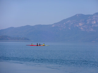 Fototapeta premium Calm surface of the lake and sportsmen on a kayak