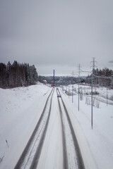 Obraz premium tire tracks on a road covered in snow in a rural area in Finland 