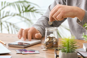 Businessman with calculator counting money at workplace