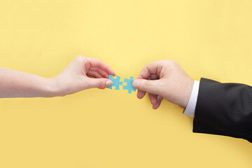 The female hand and the male hand connect the puzzles