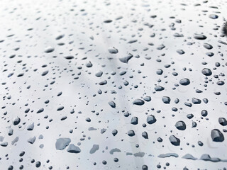 water drops on black car roof after stopped raining , selective focus