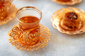 Turkish baklava and Turkish tea in oriental dishes on gray background