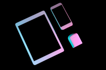 Tablet computer, mobile phone and wireless earphones on dark background