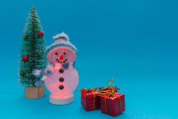 Glows in the dark snowman, presents and Christmas tree with copy space.new year celebration.