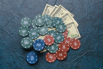 Poker chips and dollar banknotes on dark background