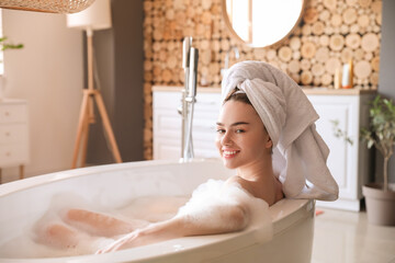 Young woman taking bath with foam at home - Powered by Adobe