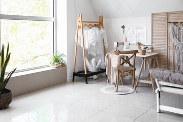 Interior of modern tailor's workshop with clothes