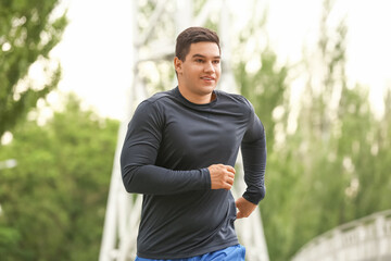 Muscular young man running outdoors