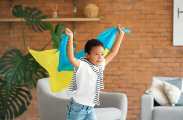 Happy African boy with Ukrainian flag at home
