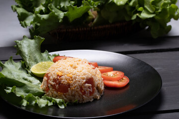 Red salted egg fried rice with vegetables in black plate