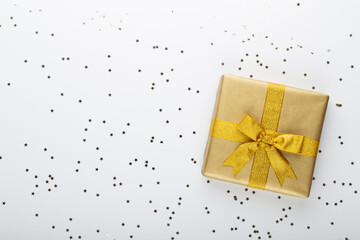 Gift or present box and stars confetti on color table top view. Flat lay composition for birthday, mother day or wedding.