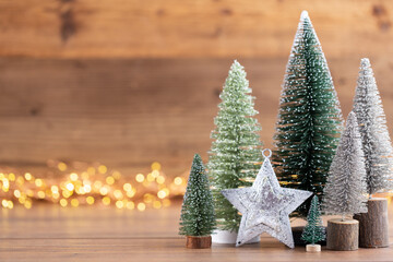 Colorful Christmas tree on wooden, bokeh background.