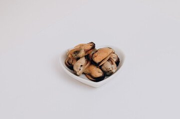 white plate of mussels on a white background