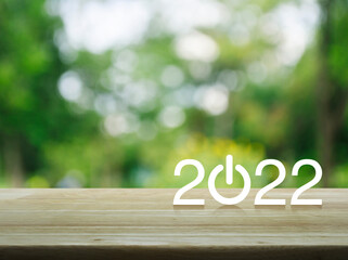 2022 start up business flat icon on wooden table over blur green tree in park, Happy new year 2022...
