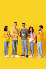 Team of young business people on yellow background