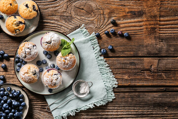 Composition with tasty blueberry muffins and berries on wooden background