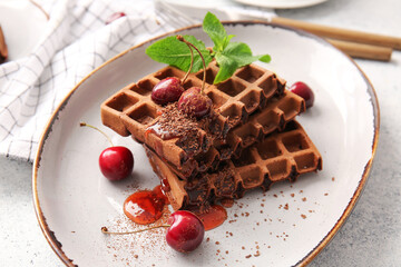 Plate of delicious Chocolate Belgian Waffles with cherry on white background