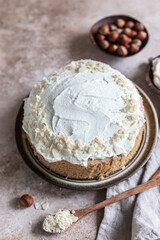 Homemade sponge cake or biscuit with nuts and spices decorated with butter cream or cream cheese icing.