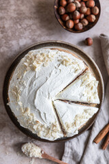 Homemade sponge cake or biscuit with nuts and spices decorated with butter cream or cream cheese icing.