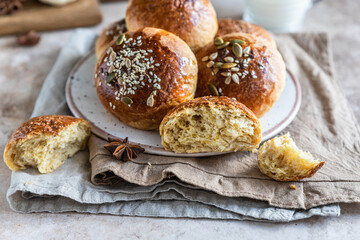 Fresh homemade pumpkin buns with brown sugar or seeds, light concrete background. Autumn bakery.