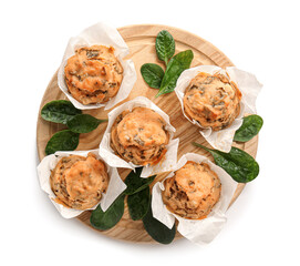Wooden board with tasty spinach muffins on white background