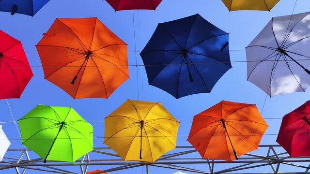 Colorful umbrellas. Bottom view. Conceptual art object. No labels or identification marks. Place for your text. Colorful background. Concept of a good mood and protection from problems. Sky is visible