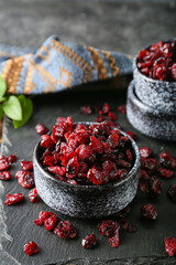 Bowl with tasty dried cranberries on table, closeup