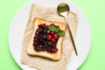 Delicious toast with cranberry jam on plate against color background, closeup
