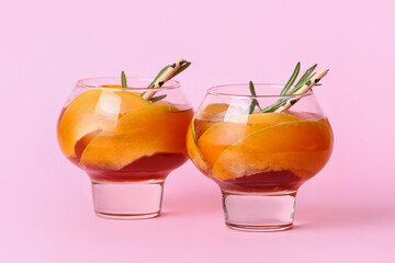 Glasses of cold melon cocktail on pink background