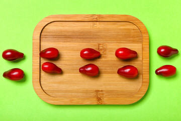 Composition with fresh dogwood berries on color background